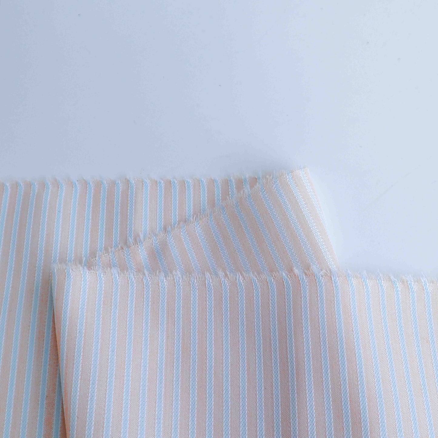 Lightweight stripes fabric in pink beige colour. This is poly-rayon blend fabric is soft to touch. The polyester blended composition adds extra durability.