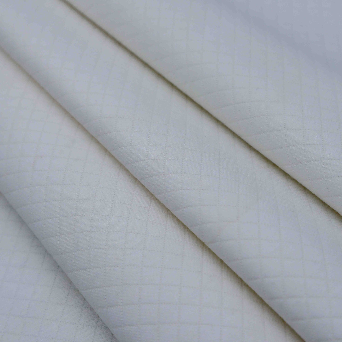 A mid-weight textured fabric in Porcelain. This fabric has a quilt look-a-like texture to it and is stretchable due to the spandex blend in fabric composition. It is breathable despite its weight.